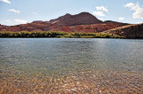 Bottling the Colorado River. Mountain of red sandstone and thin water ripples