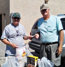 Alan Friedman, left, presenting both cash and donated food items to a representative of the Casa Grande Food Bank after a fundraiser benefiting their organization.