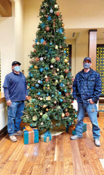 Maintenance team members Kacey and Alex set up and decorated the Christmas tree with the help of Marco (not shown).