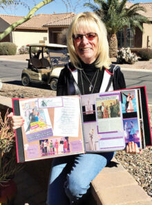 Linda Gayer holding scrapbook