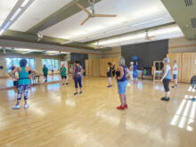 Intermediate class getting steps from instructor, CJ, in the aerobics room.