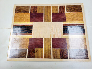 This is a one-of-a-kind serving tray made from a variety of woods. It measures 12.5-inches by 16.5 inches.