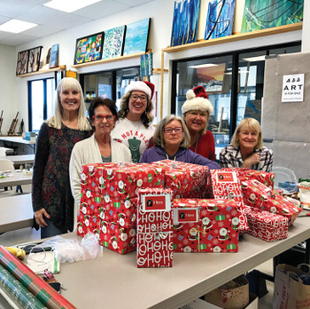 Volunteers with wrapped gifts for local seniors.