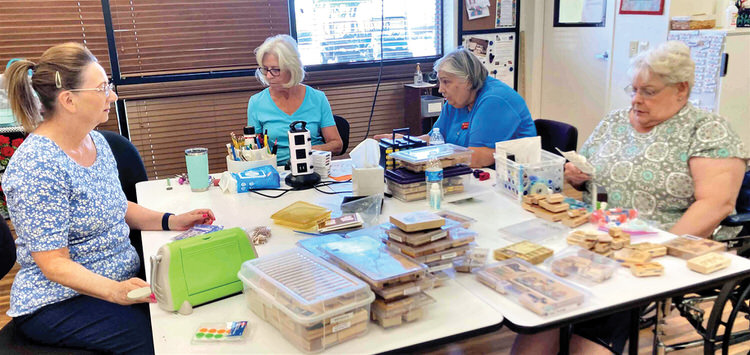 Left to right: Trudy Foslien, Lorraine Walden, Michele Skinner, and Georgia Brosnihan sort through donated paper crafting supplies.